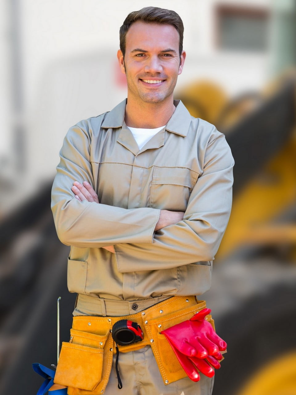 Digital composition of worker standing with arms crossed against construction site in background